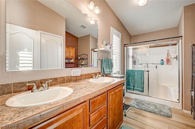 bathroom with hardwood / wood-style flooring, a shower with shower door, lofted ceiling, and vanity