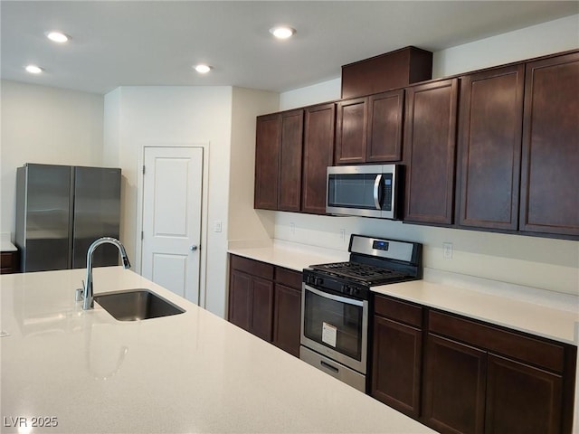 kitchen featuring sink, stainless steel appliances, and dark brown cabinetry