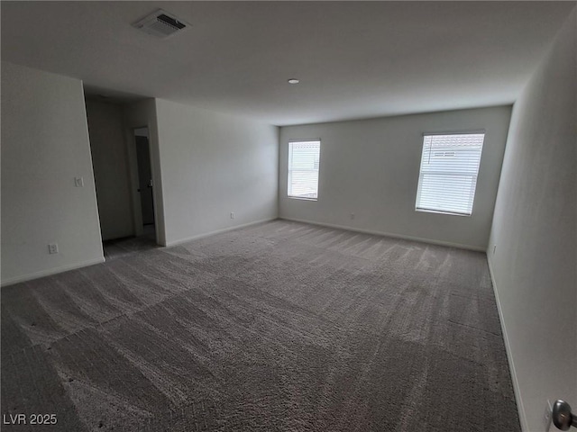 spare room with dark carpet