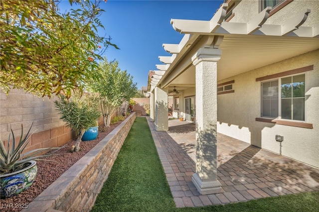 view of yard featuring ceiling fan and a patio