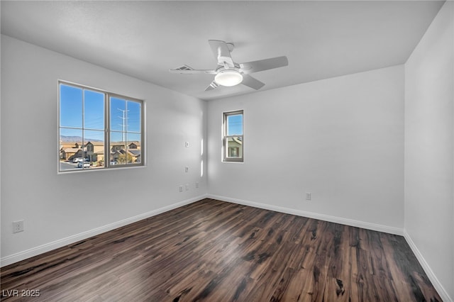 empty room featuring dark wood-type flooring and ceiling fan