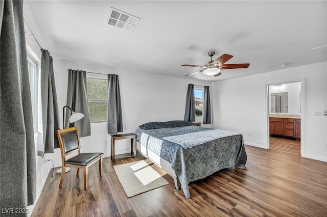 bedroom with wood-type flooring, connected bathroom, and ceiling fan