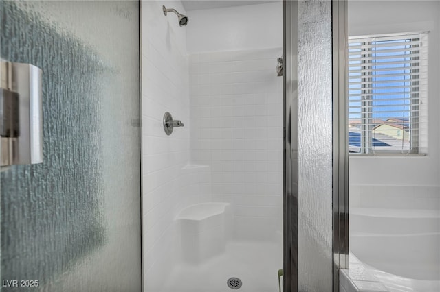 bathroom with a healthy amount of sunlight and separate shower and tub