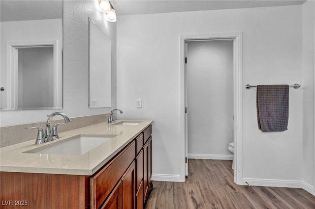 bathroom with vanity, toilet, and wood-type flooring