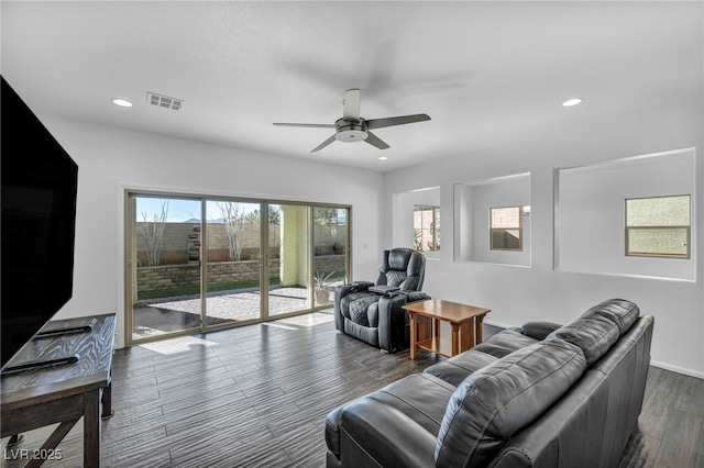 living room featuring ceiling fan and dark wood-type flooring