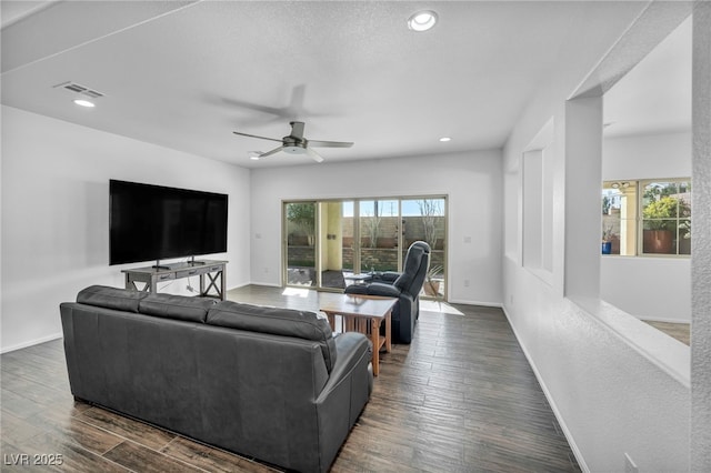 living room featuring dark wood-type flooring and ceiling fan