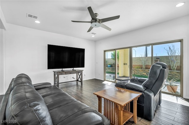 living room with ceiling fan and dark wood-type flooring