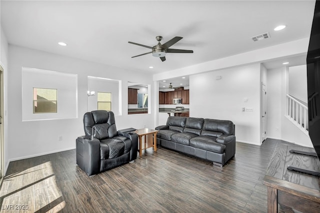 living room featuring ceiling fan and dark hardwood / wood-style flooring