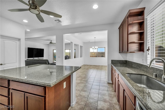 kitchen featuring sink, hanging light fixtures, dark stone counters, and light tile patterned flooring