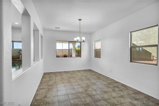 unfurnished room with an inviting chandelier