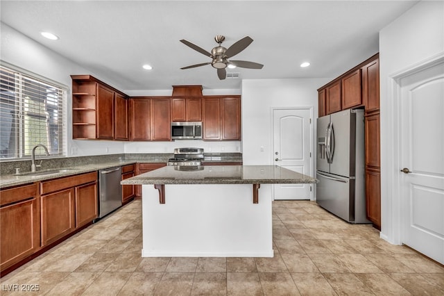 kitchen with a kitchen island, stainless steel appliances, dark stone countertops, a kitchen breakfast bar, and sink