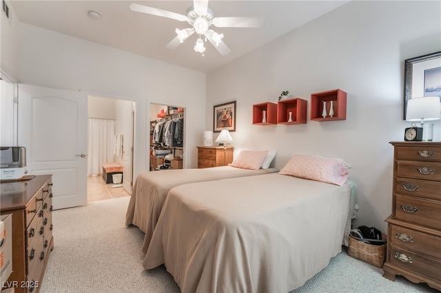 carpeted bedroom with ceiling fan, connected bathroom, a closet, and a walk in closet