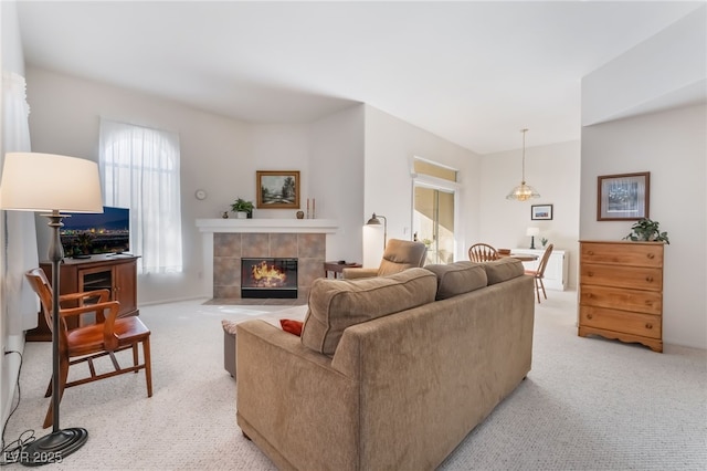 carpeted living room featuring a tiled fireplace