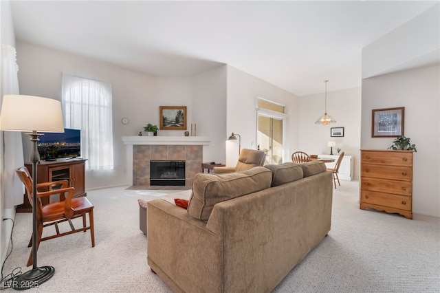 carpeted living room featuring a tile fireplace