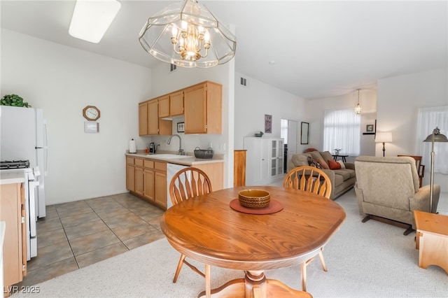 dining space featuring sink, a chandelier, and light tile patterned flooring