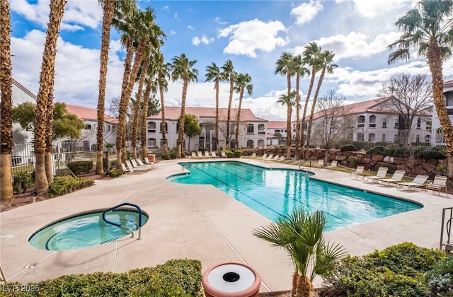 view of swimming pool featuring a hot tub and a patio