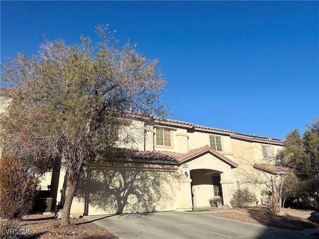 mediterranean / spanish-style home featuring central AC and a garage