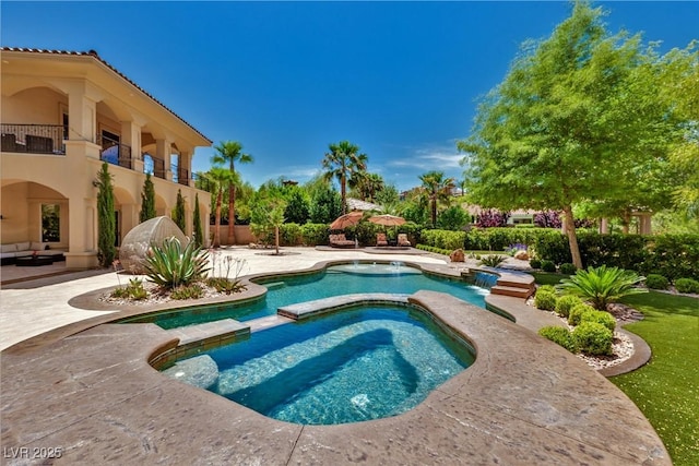 view of swimming pool with an in ground hot tub and a patio