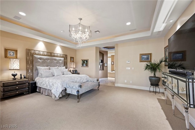 bedroom with light colored carpet, a chandelier, and a tray ceiling