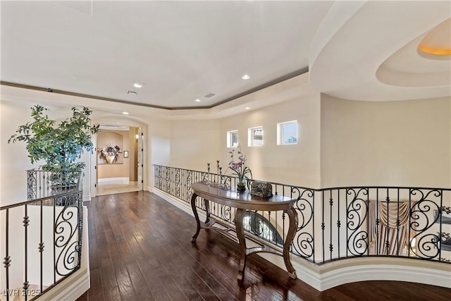 corridor featuring a raised ceiling and dark hardwood / wood-style floors