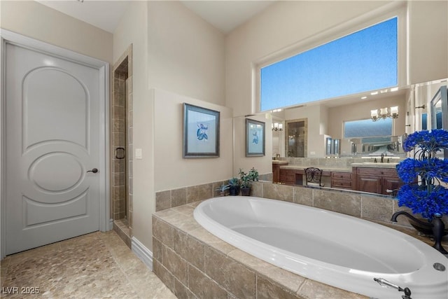 bathroom featuring vanity, shower with separate bathtub, and a notable chandelier