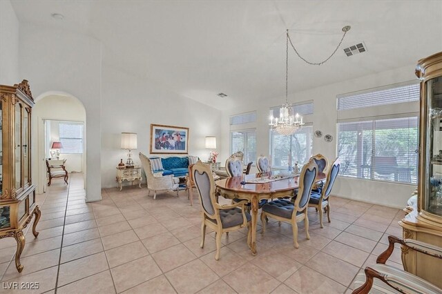 dining room featuring light tile patterned flooring, a healthy amount of sunlight, and an inviting chandelier