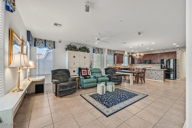 living room featuring light tile patterned floors and ceiling fan with notable chandelier