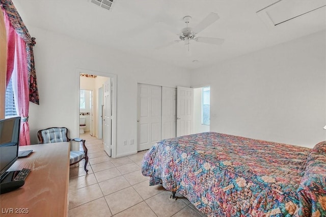 tiled bedroom with ceiling fan, ensuite bath, and a closet