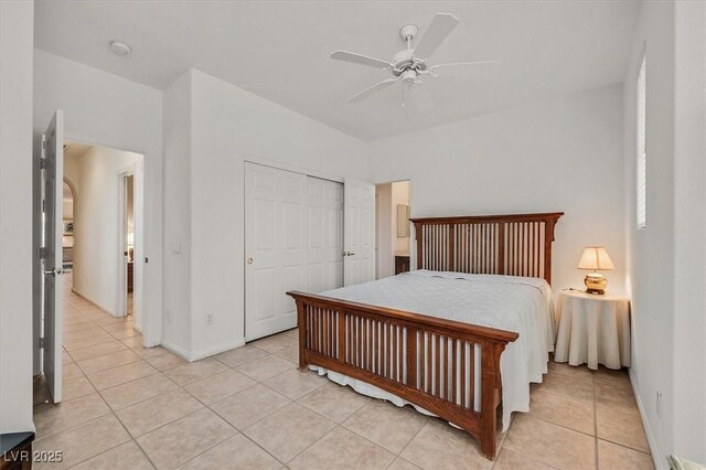 tiled bedroom featuring ceiling fan and a closet