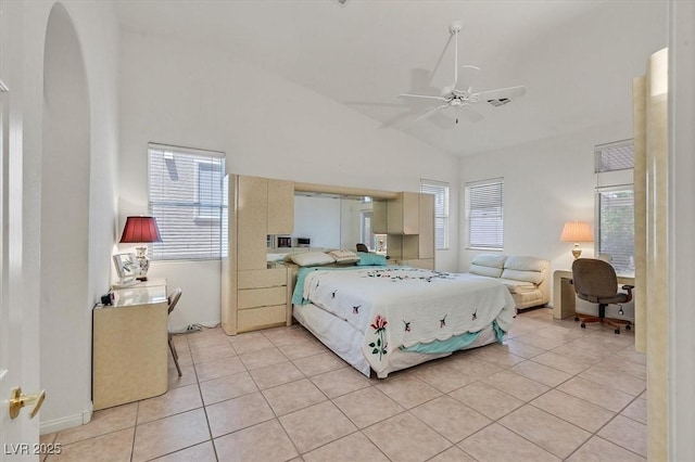 tiled bedroom featuring multiple windows, lofted ceiling, and ceiling fan