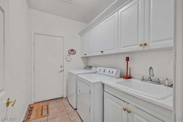 washroom featuring cabinets, sink, washing machine and dryer, and light tile patterned floors