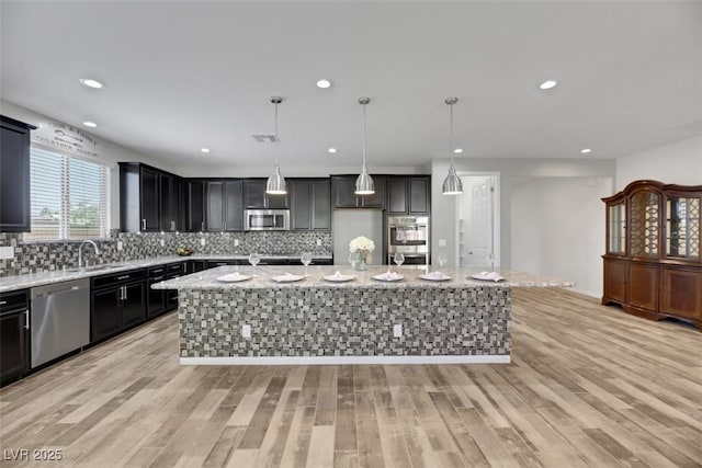 kitchen featuring hanging light fixtures, a center island, and appliances with stainless steel finishes