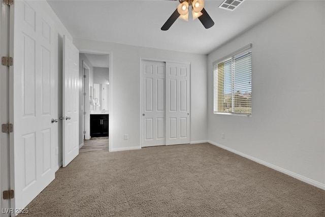 unfurnished bedroom featuring ceiling fan, connected bathroom, carpet floors, and a closet