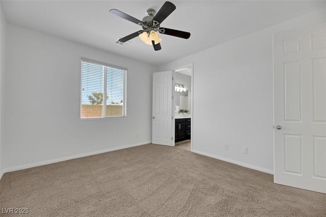 unfurnished bedroom with connected bathroom, light colored carpet, and ceiling fan