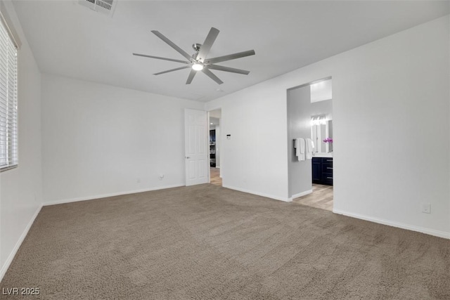 spare room with ceiling fan and light colored carpet