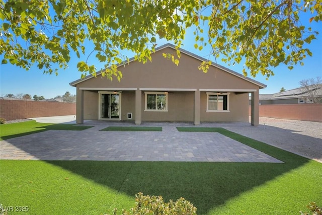 rear view of house with a patio and a lawn