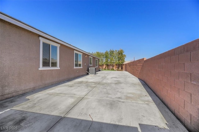 view of side of property with a patio and central air condition unit