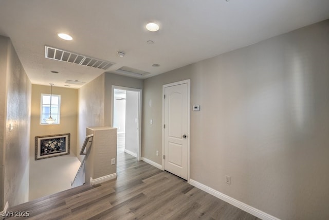 corridor with hardwood / wood-style flooring