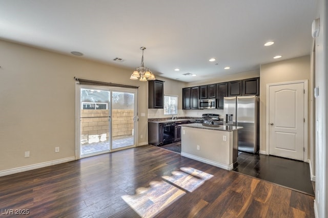 kitchen with stainless steel appliances, a center island, pendant lighting, and dark wood-type flooring