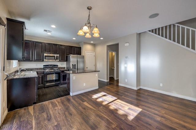 kitchen featuring appliances with stainless steel finishes, a center island, sink, and dark hardwood / wood-style floors