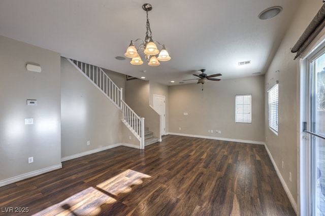 unfurnished living room featuring ceiling fan with notable chandelier and dark hardwood / wood-style flooring