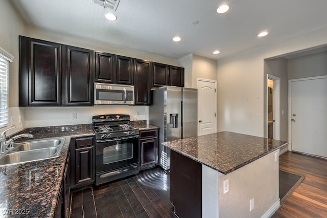 kitchen with a kitchen island, appliances with stainless steel finishes, sink, and dark wood-type flooring