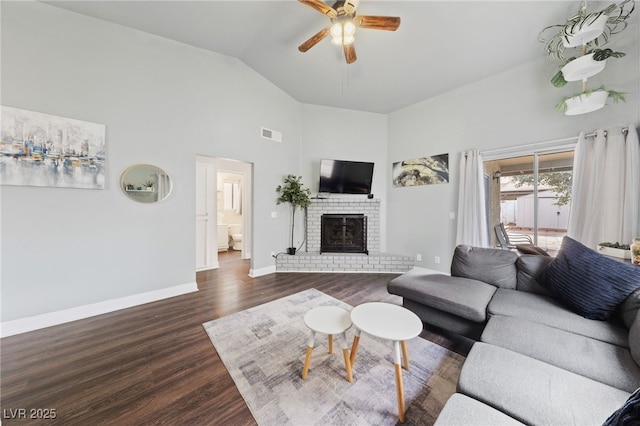 living room featuring a brick fireplace, dark hardwood / wood-style floors, lofted ceiling, and ceiling fan