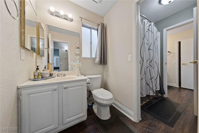 bathroom with hardwood / wood-style flooring, vanity, and toilet