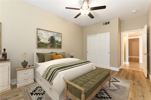 bedroom featuring light hardwood / wood-style floors, ceiling fan, and a closet