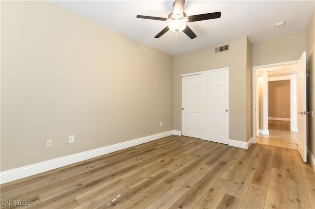 unfurnished bedroom with hardwood / wood-style floors, a closet, and ceiling fan