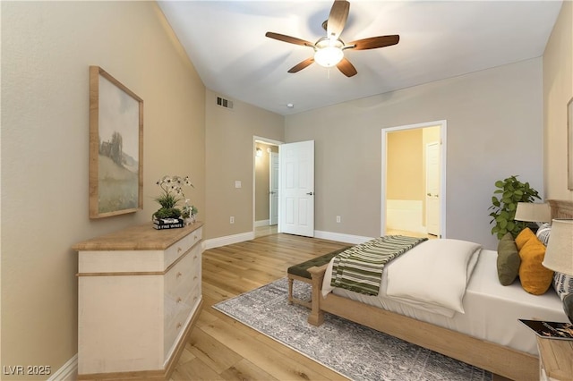 bedroom with ceiling fan, ensuite bath, and light wood-type flooring