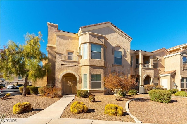 view of front of property with a balcony and central AC unit