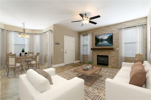 living room with ceiling fan with notable chandelier, a tile fireplace, and light tile patterned floors