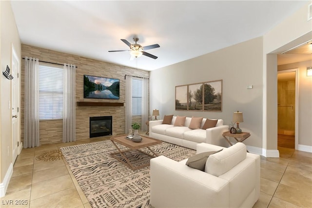 tiled living room featuring a tiled fireplace and ceiling fan